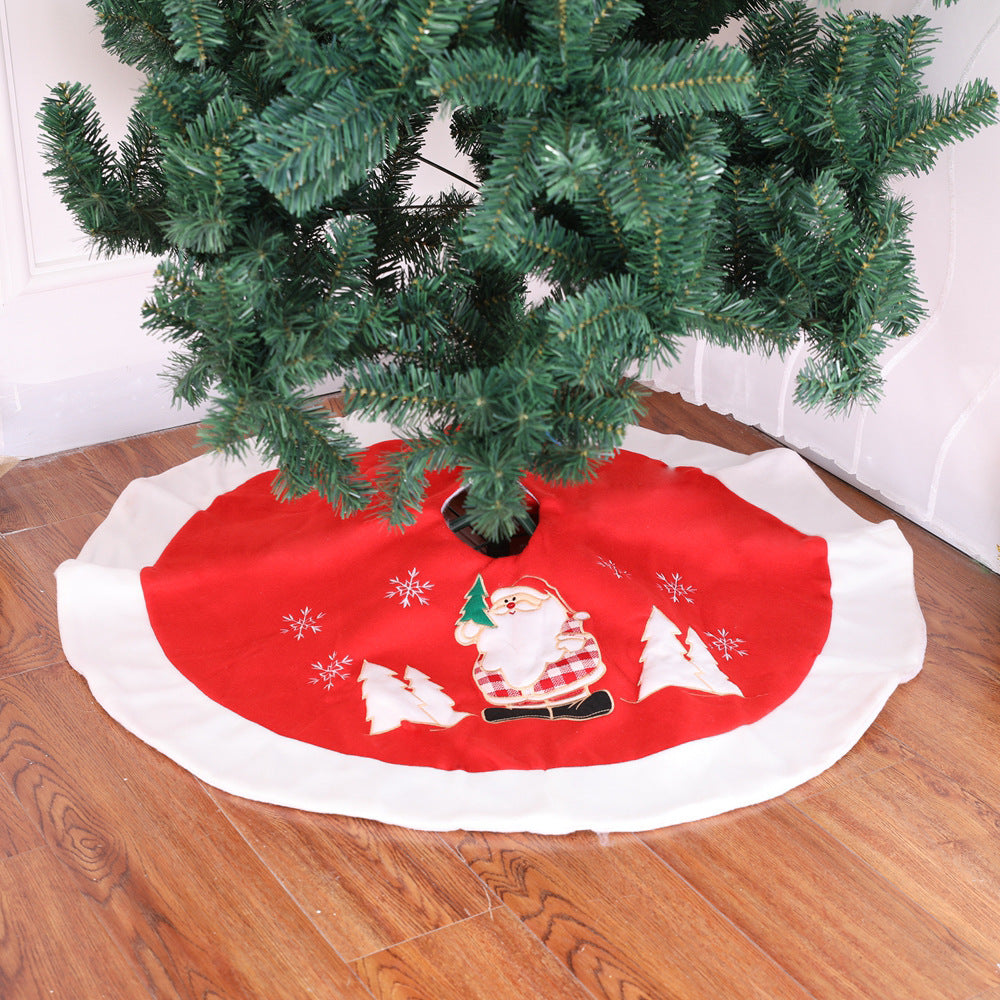 Red Christmas tree skirt with Santa Claus design under a decorated tree on a wooden floor.
