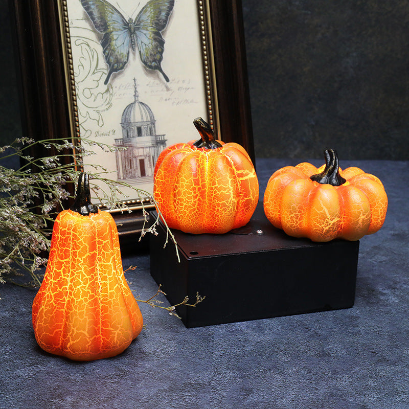 Three decorative pumpkins on a dark surface with a framed picture of a butterfly and building in the background.
