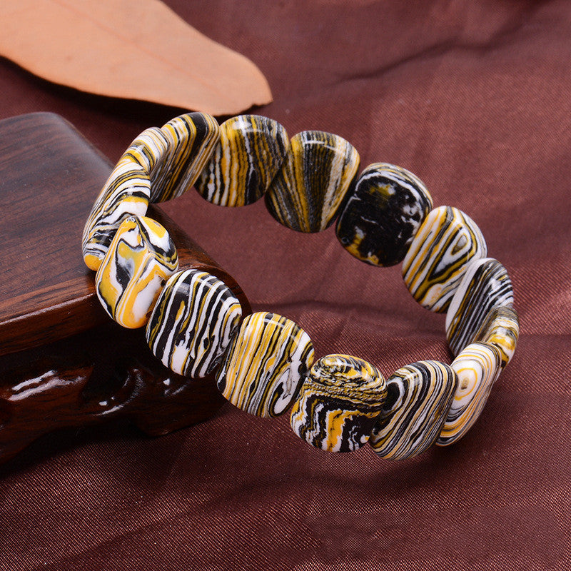 Decorative bracelet with marbled pattern on a brown fabric background