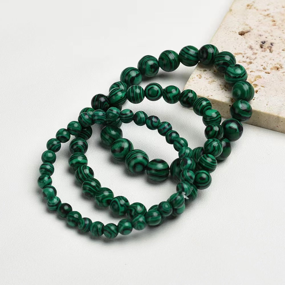 Green beaded bracelets on a light background