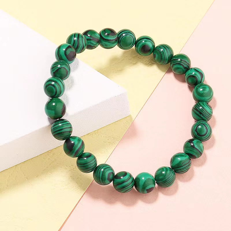 Green and black beaded bracelet on a colorful background
