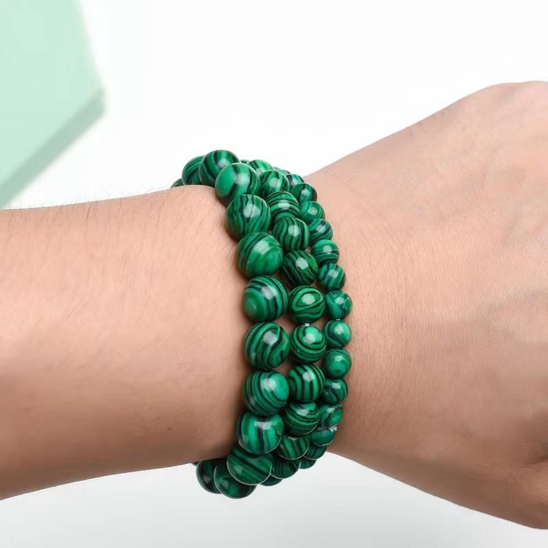 Green marbled bracelet on a wrist with a blurred background