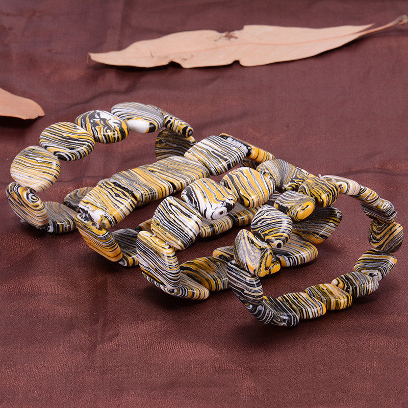 Decorative snake sculpture with marbled pattern on a brown fabric background