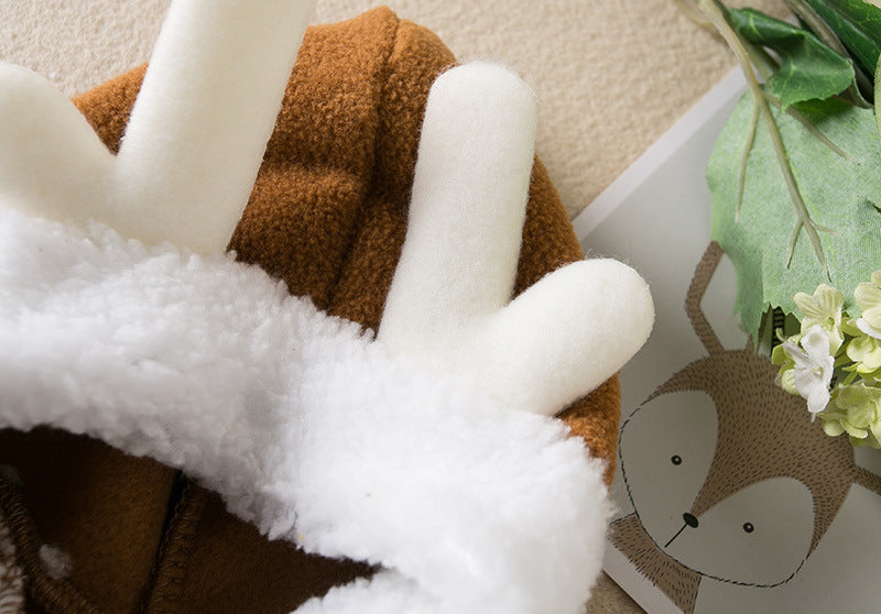 Close-up of a plush toy with white fur and brown body, next to a decorative item with a face.