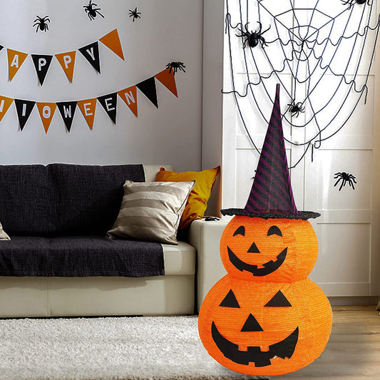 Halloween-themed room with pumpkin decoration, spider webs, and 'Happy Halloween' banner.