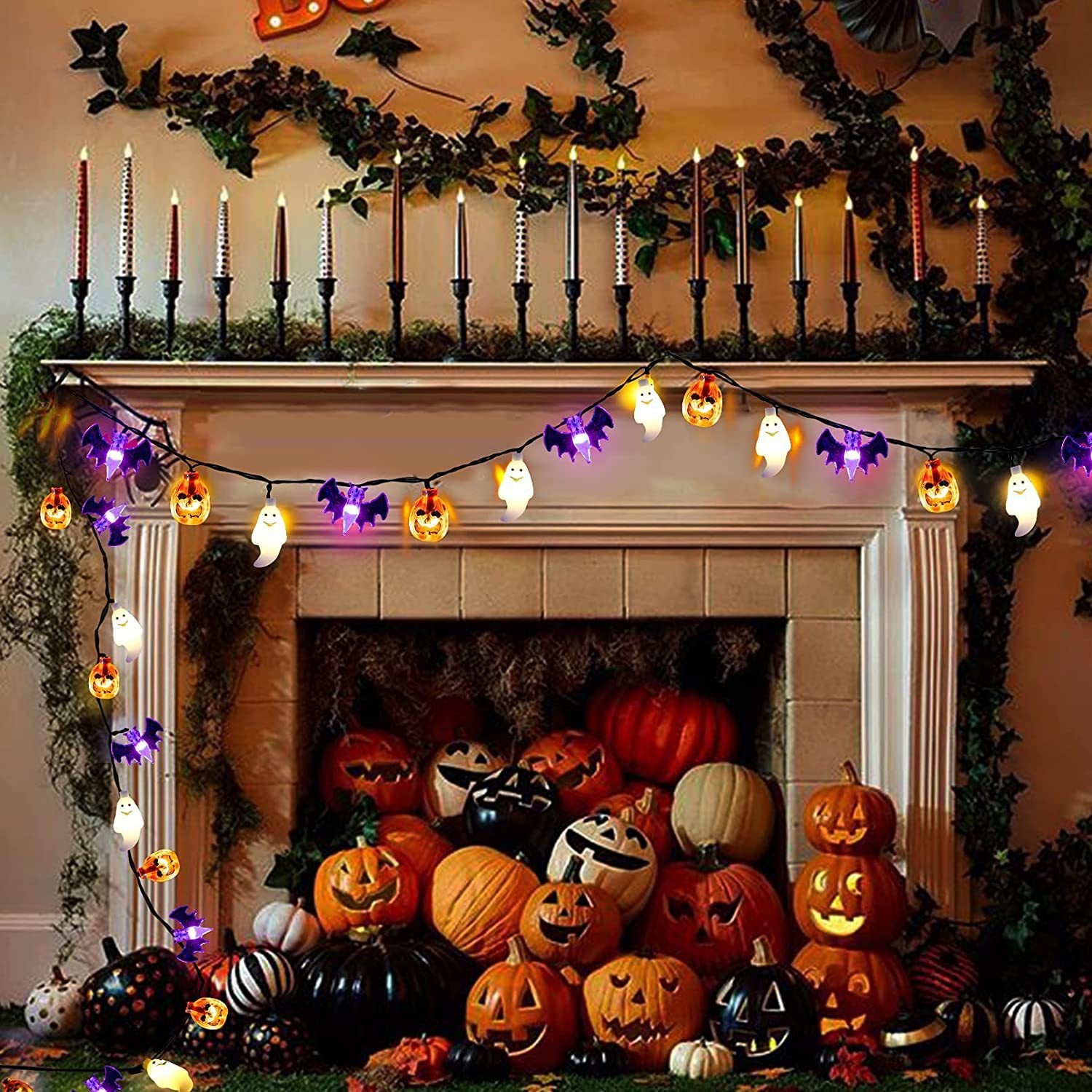 Halloween-themed fireplace with pumpkins, candles, and string lights.